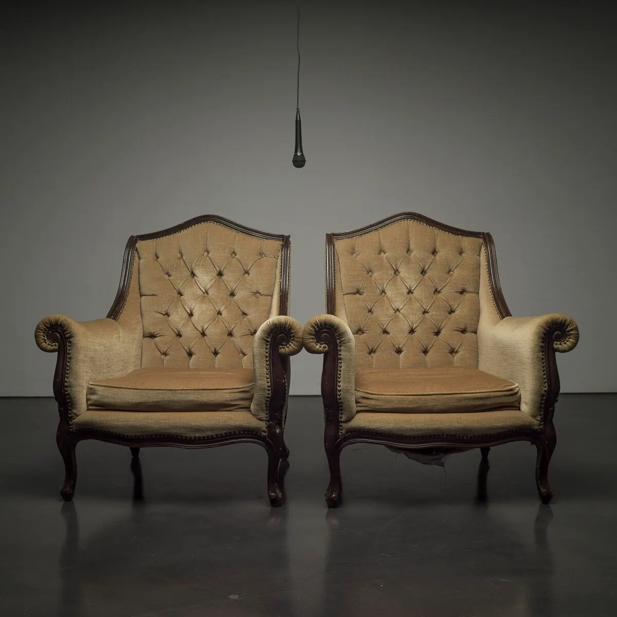 Two empty armchairs side by side in a grey room